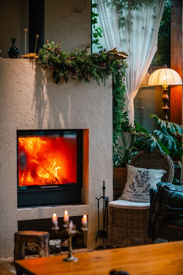 Fireplace mantel with a pine garland draped along the shelf in a lived-in living room