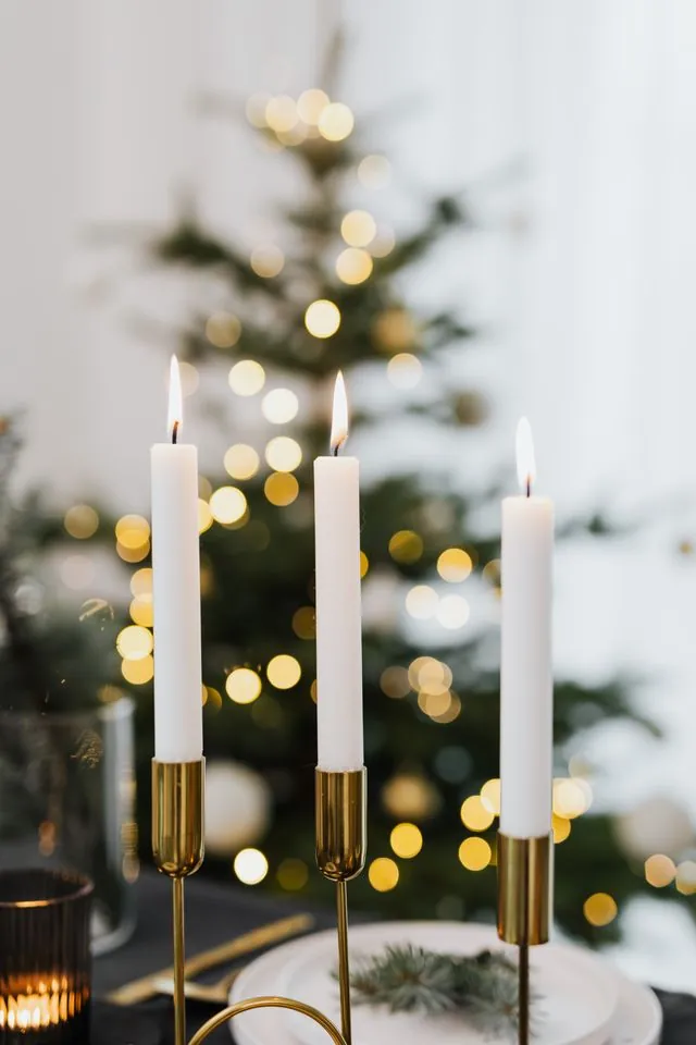 Brass candlesticks with white taper candles at different heights