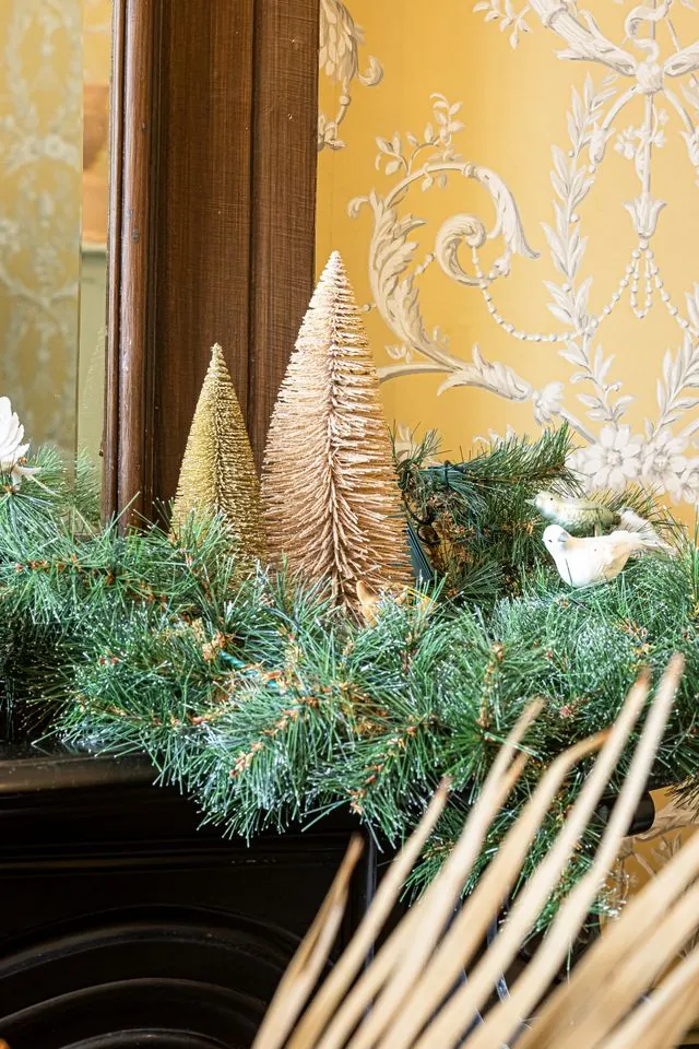 Cream bottle brush trees tucked into a pine garland
