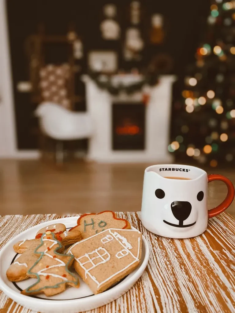 A plate of homemade gingerbread cookies and a mug by a Christmas tree, a free weekend at home instead of a paid outing