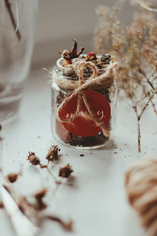 Glass jar of homemade sweets tied with twine, a homemade Christmas gift in a jar