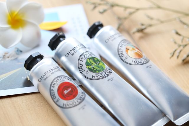 Three tubes of hand cream on a wooden table, refilling the hand cream she already uses