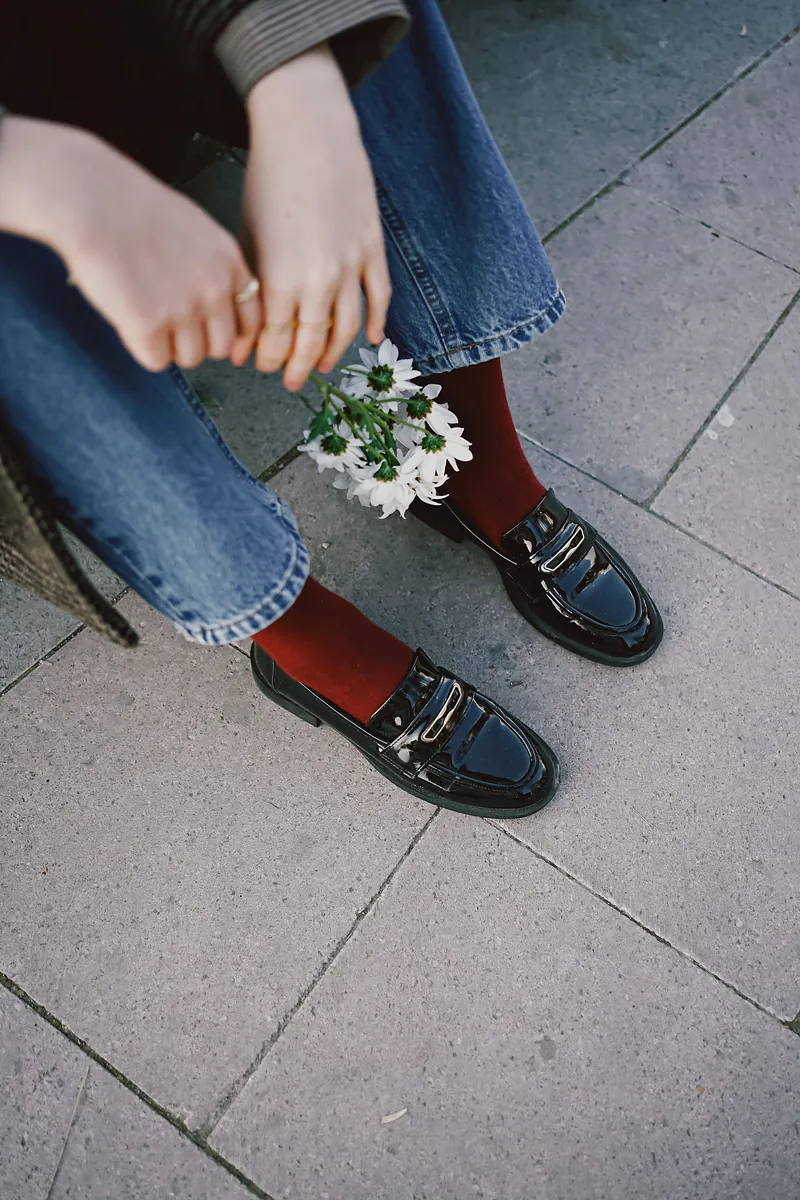 Burgundy socks with black loafers and straight jeans, a burgundy sweater outfit repeating the color once